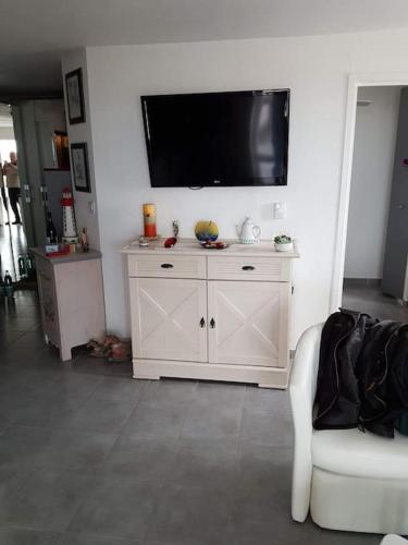 - un salon avec une grande télévision murale dans l'établissement Appartement, au Cap d'Agde