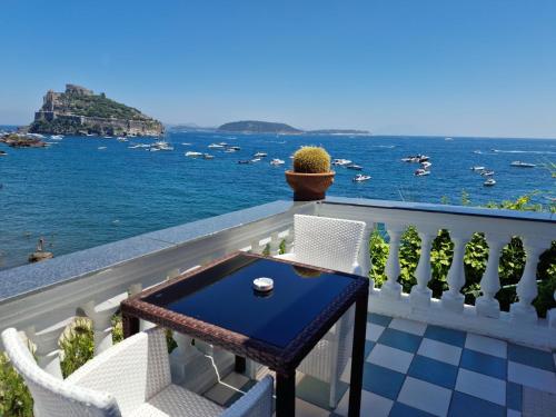 a balcony with a table and chairs and the ocean at Hotel Da Maria in Ischia