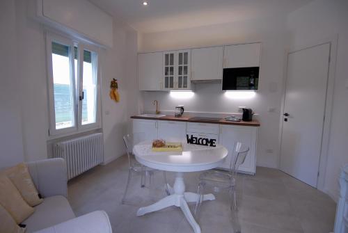 cocina con mesa blanca, mesa y sillas en Le Case di Elena - Gignese, en Gignese