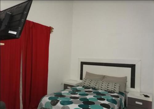 a bedroom with a bed and a flat screen tv at NFT in Cancún
