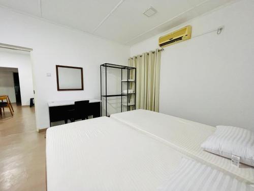 a white bedroom with a bed and a piano at The Colombo Home in Nugegoda