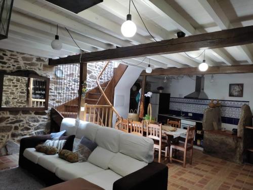 un soggiorno con divano bianco e tavolo di Casa rural de piedra en una aldea tranquila de Zas 