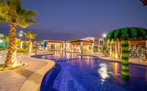 een zwembad met palmbomen in een resort bij Casa “PLAYA DORADA” in Mazatlán