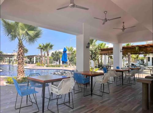 a patio with tables and chairs and a pool at Casa “PLAYA DORADA” in Mazatlán