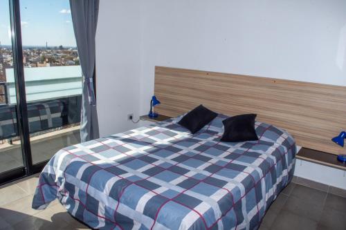 a bed in a room with a large window at Nuevo Natania Vista Cordillera in Godoy Cruz