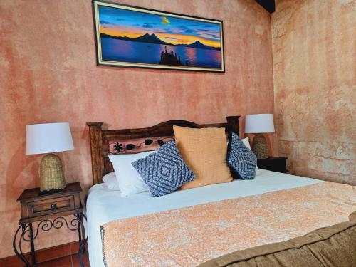 a bedroom with a bed and a picture on the wall at Hotel Boutique Casa Del Ángel in Antigua Guatemala