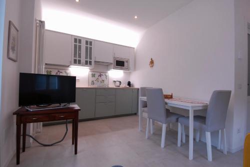 sala de estar con mesa y cocina en Le Case di Elena - Gignese, en Gignese