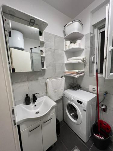 Un baño con lavadora y lavabo. en Centrino Apartment, en Split