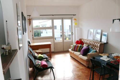 a living room with a couch and a table at Peniche Housing | Tree The Company in Peniche
