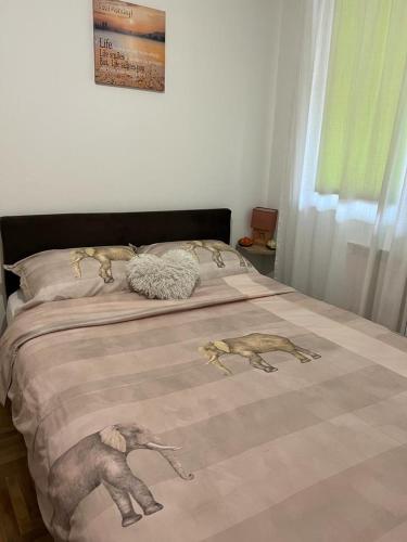 łóżko z kocem ze zwierzętami na nim w obiekcie Apartman Manja w mieście Lukavica