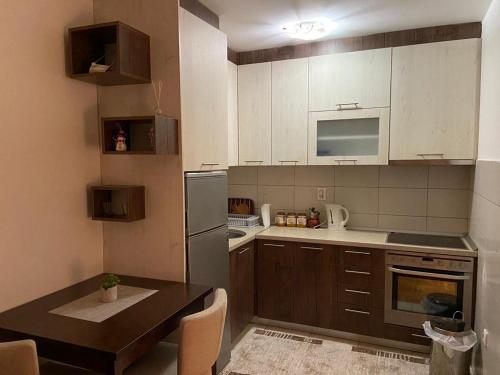 mała kuchnia ze stołem i lodówką w obiekcie Apartman Manja w mieście Lukavica