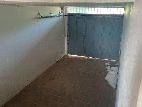 an empty garage with blue doors and a brick floor at Villa Celeste in Arboletes