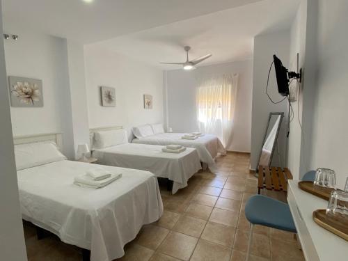 Zimmer mit 2 Betten, einem Tisch und Stühlen in der Unterkunft Alojamiento Rural Al´Mare in Conil de la Frontera