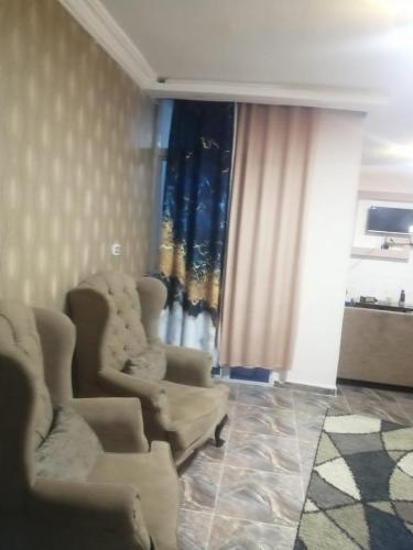 a living room with two chairs and curtains at Sea spirit in Alexandria