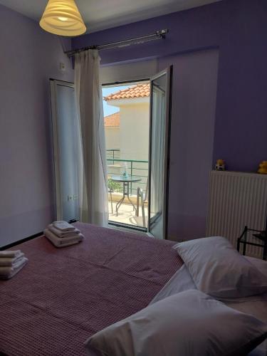 a bedroom with a large bed and a large window at Santa Marina Sxoinias in Schinias