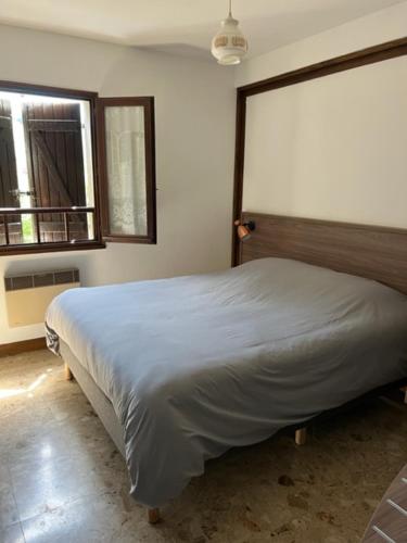 une chambre avec un grand lit dans une pièce dans l'établissement Relais des Ardides, à Bonnemazon