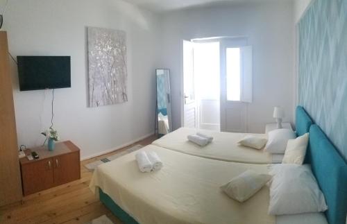 a bedroom with two beds and a television in it at Apartmani KaLu in Mlini