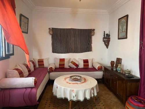 een woonkamer met een bank en een tafel bij Chez Ali in Essaouira