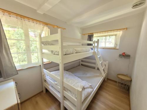 a bedroom with two bunk beds in a room at Domek Seleny w Dolinie Symsarny in Lidzbark Warmiński