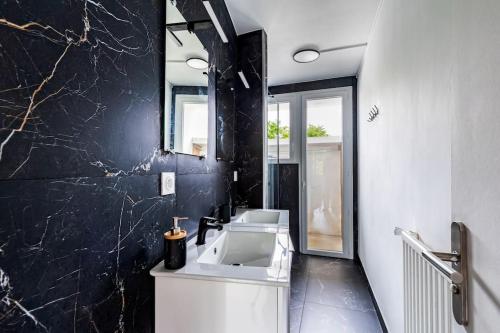 baño con lavabo y pared negra en Appartement calme et douillet, en Guingamp