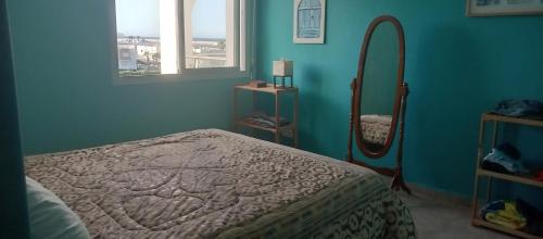 um quarto azul com uma cama e um espelho em Marina Puerto em Marina Smir