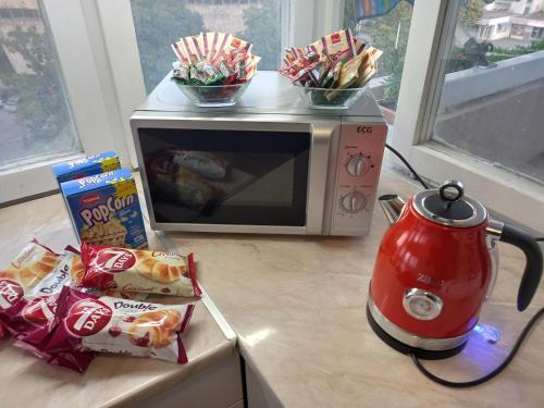 a microwave with snacks and a tea kettle on a counter at Penthouse Panorama in Čapljina