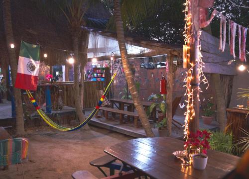a patio with a wooden table and a hammock at Kin Hostal and Camping in Holbox Island