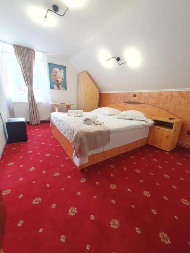 a hotel room with a bed and a red carpet at Casa Flavius in Bran