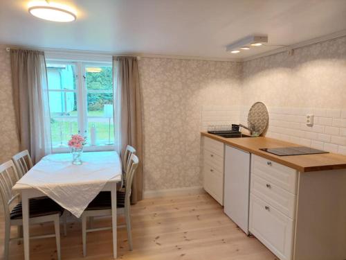 a kitchen with a table and a table and a window at Trevligt eget hus med kakelugn i lantlig miljö in Vikingstad