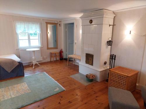 a living room with a fireplace and a couch at Trevligt eget hus med kakelugn i lantlig miljö in Vikingstad