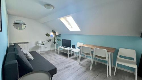un salon avec un canapé et une table avec des chaises dans l'établissement Là-haut, à Nevers