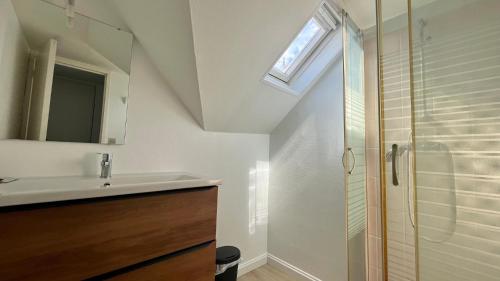 une salle de bain avec un lavabo et une douche dans l'établissement Là-haut, à Nevers