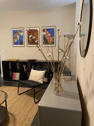 un salon avec une table avec un vase de fleurs dans l'établissement Au cœur du port - Restaurants, Bars et WIFI, à Nice