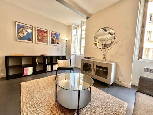 - un salon avec une table en verre et un miroir dans l'établissement Au cœur du port - Restaurants, Bars et WIFI, à Nice