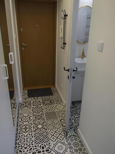 Łazienka z drzwiami i podłogą wyłożoną kafelkami w obiekcie Prague 9 apartments w Pradze