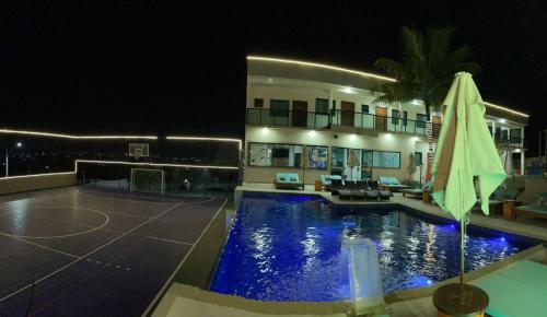 a house with a swimming pool at night at VIVER Pousada Club & Restaurante in Saquarema
