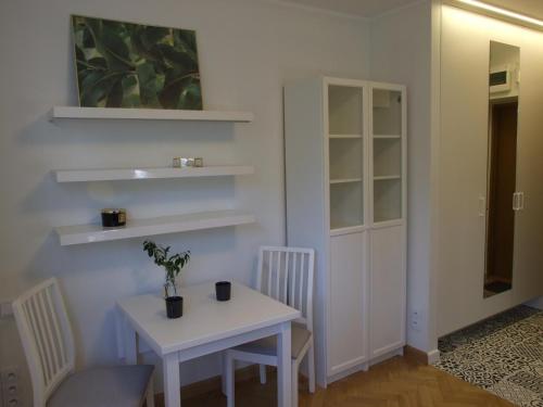 una habitación con una mesa blanca, una mesa y estanterías en Prague 9 apartments en Praga