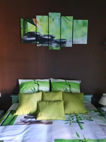 a bedroom with a bed with four paintings on the wall at Chambre zen in Motteux
