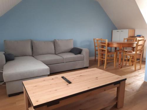 sala de estar con sofá y mesa en Agréable petit T3, à proximité de Quimper, en Ergué-Gabéric