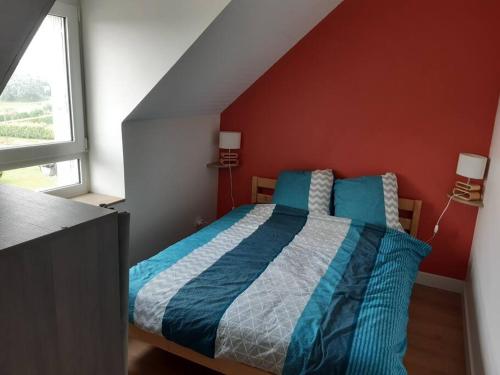 1 dormitorio con 1 cama con paredes azules y rojas en Agréable petit T3, à proximité de Quimper, en Ergué-Gabéric