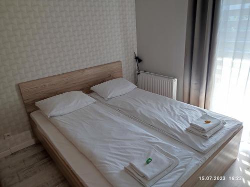 Una cama con sábanas blancas y almohadas en un dormitorio en Apartament Gołebiewskiego w Bydgoszczy en Bydgoszcz