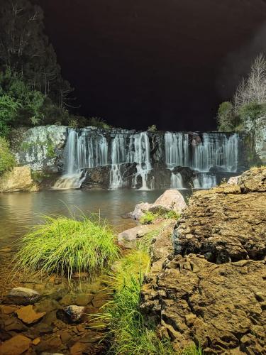 a waterfall in the middle of a river at night at POUSADA SOL DA SERRA in Bom Jardim da Serra