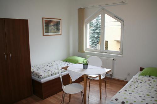 mały pokój z łóżkiem, stołem i krzesłami w obiekcie TJ Lokomotiva Mariánské Lázně w Mariańskich Łaźniach