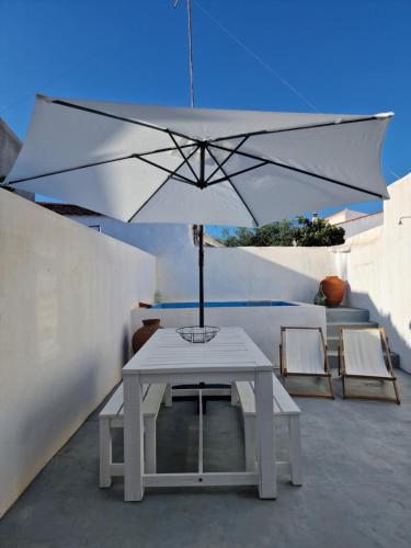 a white table with an umbrella on a patio at Casa de Santa Margarida in Mourão