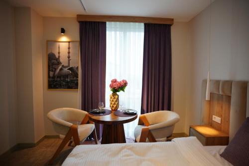 une chambre d'hôtel avec une table, des chaises et une fenêtre dans l'établissement luxury suite 13, à Istanbul