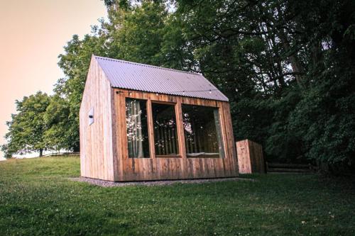 ein kleiner Holzschuppen auf einem Grasfeld in der Unterkunft Na seně in Kozlovice
