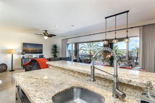 a kitchen with a sink and a living room at Ventanas Condo with Pool in Cabo San Lucas