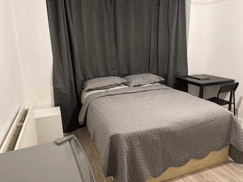 a bedroom with a bed and a side table at Hallykins in Erith