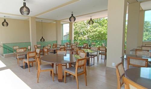 un comedor con mesas, sillas y ventanas en Star Palace Hotel Jeri, en Jericoacoara