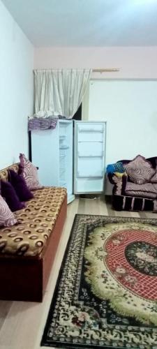 een woonkamer met een bank en een tapijt bij العجمي البيطاش بيانكى in Alexandrië